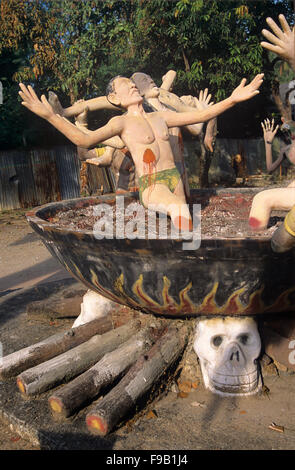 Betonskulptur von Sündern, die in der buddhistischen Hölle brennen, in Cauldron on on Fire. .Kisch Folk Art Sculpture im Wat Wang Saen Suk hell Garden im Tempelgelände, Bang Saen, Chonburi Thailand Stockfoto