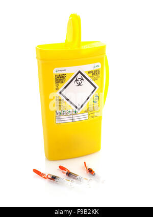Gelbe medizinische Sharps Entsorgungsbox mit drei Hypodermics auf weißem Grund Stockfoto