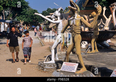 Besucher des hell Garden mit Betonstatuen von Sündern, die als Tiere wiedergekarrt sind. Kitsch-Folk-Kunstskulptur im Wat Wang Saen Suk hell Garden im Tempelgelände, Bang Saen, Chonburi Thailand Stockfoto