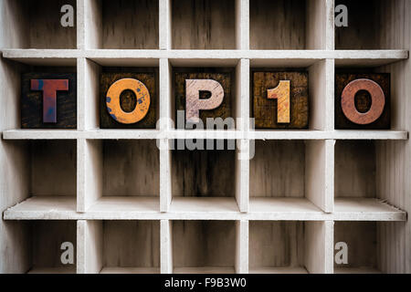 Das Wort "TOP10" Vintage Tinte geschrieben befleckte hölzerne Buchdruck-Typ in einen partitionierten Drucker Schublade. Stockfoto
