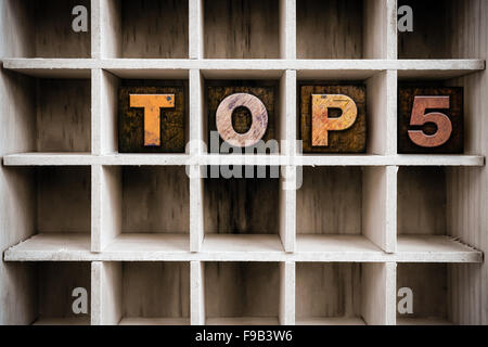 Das Wort "TOP 5" Vintage Tinte geschrieben befleckte hölzerne Buchdruck-Typ in einen partitionierten Drucker Schublade. Stockfoto