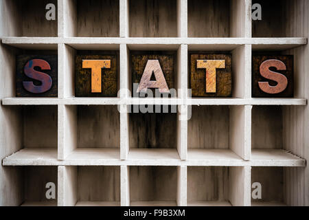 Das Wort 'STATS' Vintage Tinte geschrieben befleckte hölzerne Buchdruck-Typ in einen partitionierten Drucker Schublade. Stockfoto