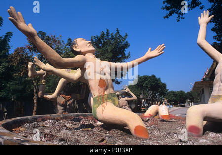 Betonskulptur von Sündern, die in der buddhistischen Hölle brennen, in Cauldron on on Fire. .Kisch Folk Art Sculpture im Wat Wang Saen Suk hell Garden im Tempelgelände, Bang Saen, Chonburi Thailand Stockfoto