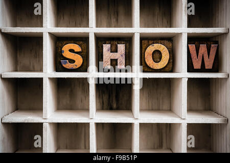 Das Wort "SHOW" in Vintage Tinte befleckte hölzerne Buchdruck-Typ in einen partitionierten Drucker Schublade geschrieben. Stockfoto