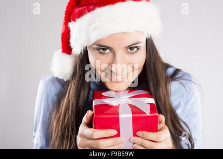 Schöne Frau mit Weihnachtsmütze hält Geschenk. Isoliert auf weißem Hintergrund. Stockfoto