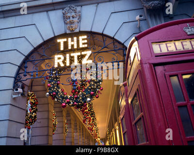 Das Ritz Hotel ist weihnachtlich dekoriert mit traditionell erhaltenen, funktionierenden roten Telefondosen im Vordergrund Londons, Großbritannien Stockfoto