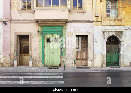 Grüne und gelbe Fassade mit vier Türen, in Malta. Stockfoto