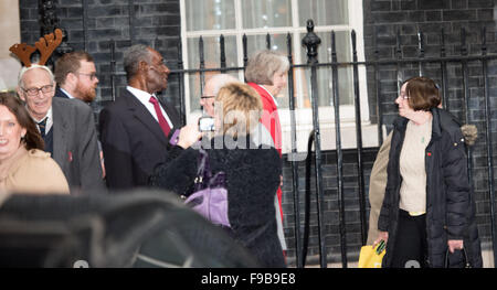 London, UK. 15. Dezember 2015. UK Innenminister, Theresa May (im roten Mantel), geht unter Weihnachten Feiernden außerhalb 10 Downing Street, London Credit: Ian Davidson/Alamy Live News Stockfoto