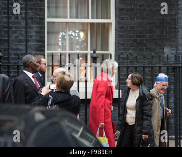 London, UK. 15. Dezember 2015. UK Innenminister, Theresa May (im roten Mantel), geht unter Weihnachten Feiernden außerhalb 10 Downing Street, London Credit: Ian Davidson/Alamy Live News Stockfoto