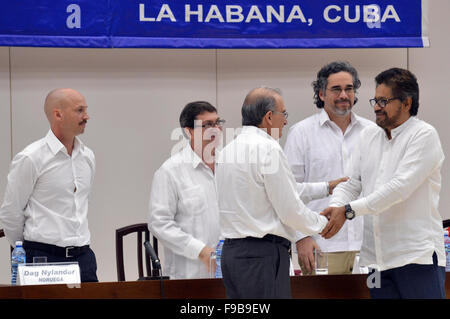 Havanna, Kuba. 15. Dezember 2015. Die kolumbianische Regierung Verhandlungsführer Humberto De La Calle (L, vorn) schüttelt Hände mit Kolumbiens revolutionäre Armad Streitkräfte Kolumbiens (FARC) Verhandlungsführer Luciano Marin Arango, alias "Ivan Marquez' (R), bei der Unterzeichnung eines Abkommens über Gerechtigkeit, am Rande der Friedensgespräche in Havanna, Kuba, 15. Dezember 2015. Kolumbianischen Regierung und der Guerilla der FARC Dienstag angekündigt, dass sie eine Einigung über die Frage der Reparationen und Gerechtigkeit für die Opfer von bewaffneten Konflikten, Schlüssel zum Friedensprozess erreicht. © Omar Nieto/COLPRENSA/Xinhua/Alamy Live-Nachrichten Stockfoto