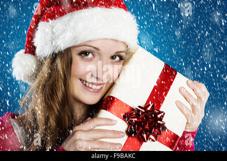 Schöne Frau mit Weihnachtsmütze auf blaue Winter Hintergrund mit Schneeflocken Stockfoto