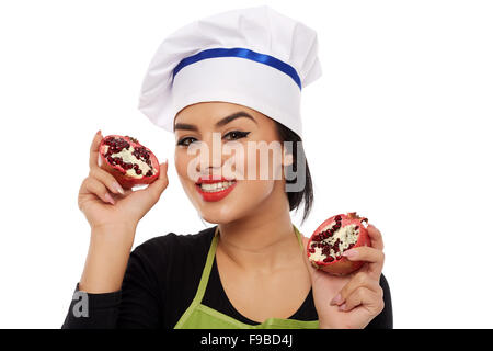 Junge Frau Koch mit in Scheiben geschnittenen Granatapfel-Frucht Stockfoto