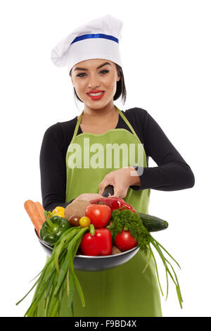 Schöne junge hispanic Koch hält viel Gemüse in einer Pfanne erhitzen Stockfoto