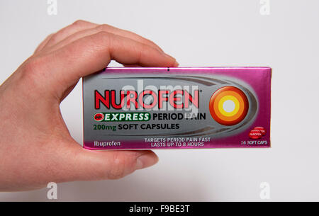 Womans Hand hält ein Paket von Nurofen Regelschmerzen Kapseln vor einem weißen Hintergrund Stockfoto