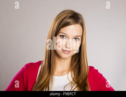 Schöne junge Frau posiert im Studio über einen grauen Hintergrund Stockfoto
