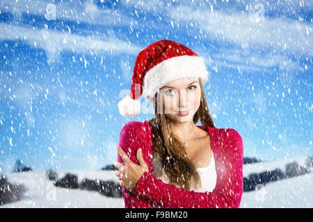 Schöne Frau mit Weihnachtsmütze im Winter Natur Stockfoto