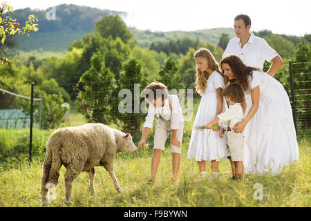 Familie mit fünf Kindern füttert die Tiere auf dem Bauernhof Stockfoto