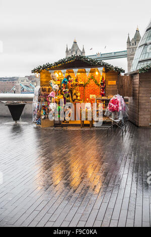 Stall, peruanische Hüte und waren in London Bridge City Christmas Market, London Borough of Southwark SE1 an einem regnerischen Tag in der Dämmerung, am frühen Abend zu verkaufen Stockfoto