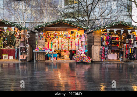 Bunte Stände auf London Bridge City Christmas Market, London Borough of Southwark SE1 an einem nassen Wintertag Stockfoto