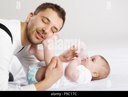 Junger Vater füttert seine kleine Tochter Stockfoto