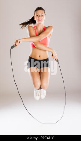 Junge aktive Frau mit Seil ist Training im studio Stockfoto