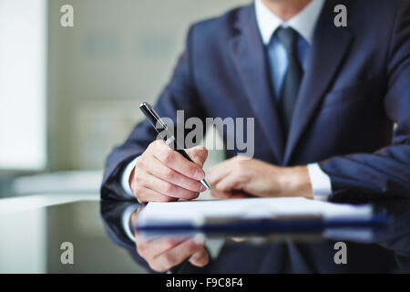 Geschäftsmann am Schreibtisch sitzen und Vertragsabschluss Stockfoto