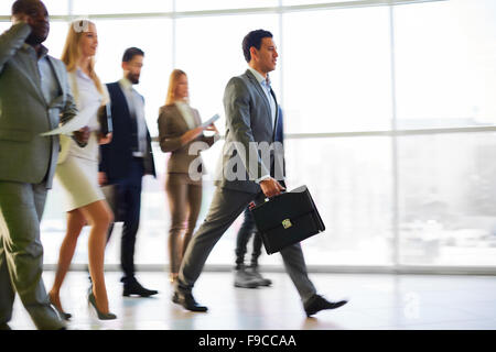 Gruppe von Geschäftsleuten, die zu Fuß auf dem Flur Stockfoto