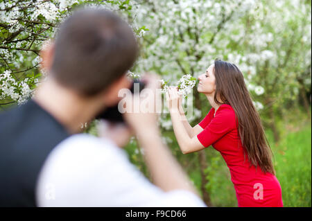Fotograf ist der schöne Frau im roten Kleid in der Natur fotografieren Stockfoto