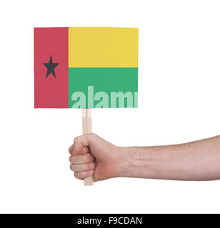 Hand, die kleine Karte, isoliert auf weiss - Flagge von Guinea Bissau Stockfoto