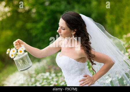 Braut im weißen Hochzeitskleid auf der Wiese Stockfoto