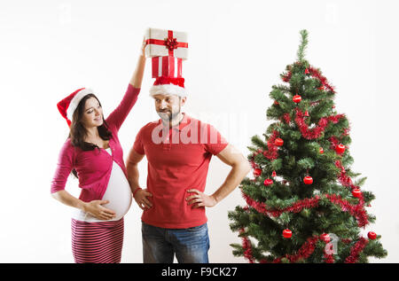 Junges Paar ist in der Nähe von Weihnachtsbaum tanzen. Frau ist schwanger. Stockfoto