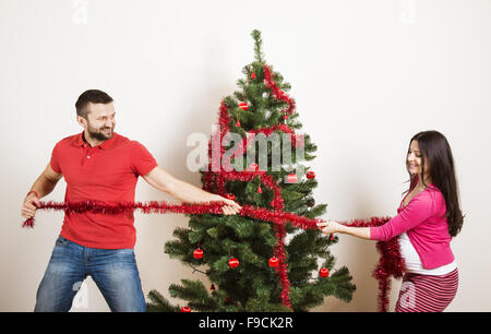 Junges Paar ist Weihnachtsbaum schmücken. Frau ist schwanger. Stockfoto