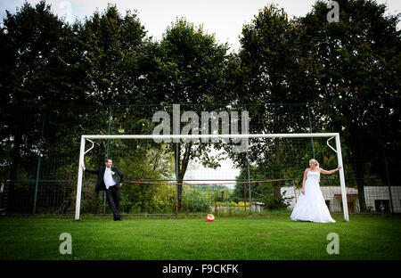 Braut und Bräutigam spielen auf dem Fußballplatz Stockfoto