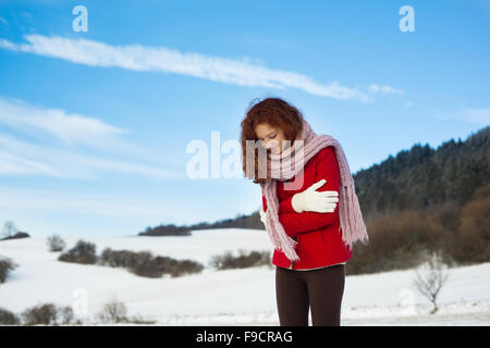 Einsames Mädchen mit dem roten Mantel posiert in verschneite Land Stockfoto