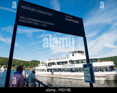 Touristen an den Ufern des Sees Rursee warten auf die Ankunft von einem Passagierschiff in der deutschen Eifel-Nationalpark. Stockfoto