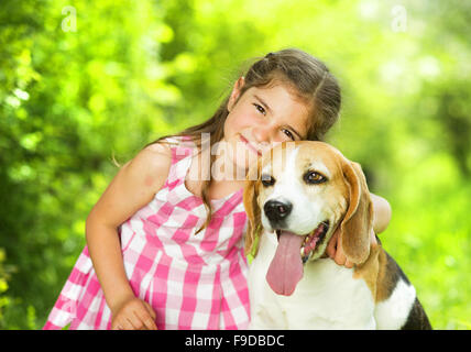 Niedliche kleine Mädchen spielt mit ihrem Hund in den grünen park Stockfoto