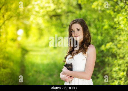 Schöne Frau mit Bibel liegt in sonnige Natur Stockfoto