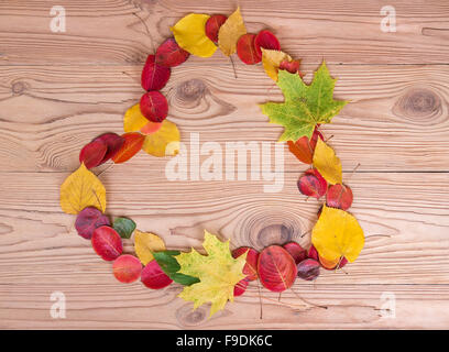 Herzförmige bunte Herbstblätter auf hölzernen Hintergrund Stockfoto