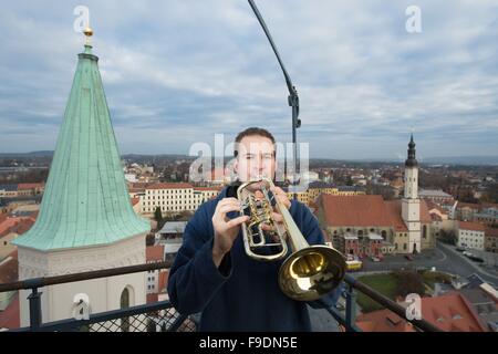 Zittau, Deutschland. 3. Dezember 2015. Wachmann Felix Weickelt spielt die Trompete vom Turm der St. Johanniskirche in Zittau, Deutschland, 3. Dezember 2015. Weickelt, Deutschlands jüngste Wächter, kümmert sich der Turm von St. John's-Kirche. Foto: SEBASTIAN KAHNERT/Dpa/Alamy Live News Stockfoto