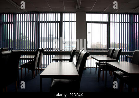 Klassenzimmer mit Tischen, Stühlen und Jalousien Stockfoto