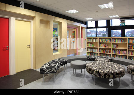 Bibliotheksbereich in eine moderne, neue Grundschule in Nottingham, UK. Zeigt gebogen, Sitzgelegenheiten, Bücherregale und Türen zu anderen Bereichen Stockfoto