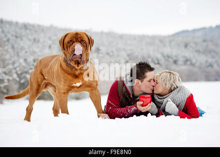 Frau und Mann haben Spaziergang mit Hund in verschneiter Winterlandschaft Stockfoto