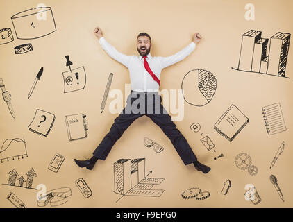 Glücklich-Manager in einer siegreichen Pose hoch springen. Studio auf einem beigen Hintergrund gedreht. Stockfoto