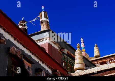 Vergoldetes Messing und Stoff Dhvajas-Sieg Banner auf Dach-blau Stoffvorhang. Schrein auf dem Gelände Sakya Kloster-Tibet. Stockfoto