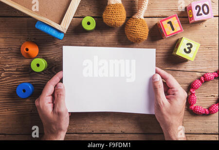 Leeren Blatt Papier und Spielzeug auf dem Boden. Studio auf hölzernen Hintergrund gedreht. Stockfoto