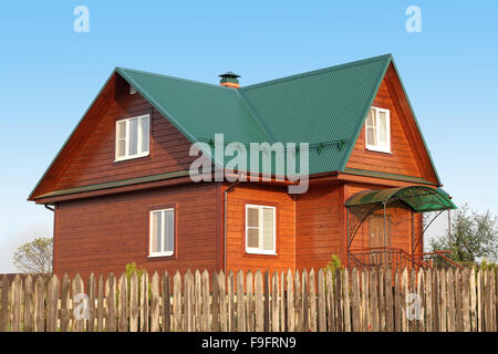 Holzhaus unter grünen Metalldach mit weißen Kunststoff-Fenster mit Jalousie Foto Stockfoto