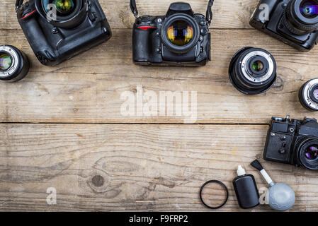 Mischen von alten Kameras auf hölzernen Schreibtisch-Hintergrund. Stockfoto