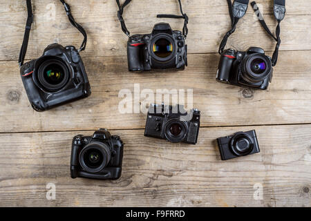 Mischen von alten Kameras auf hölzernen Schreibtisch-Hintergrund. Stockfoto