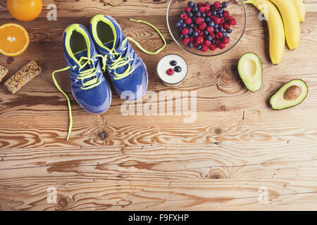 Paar Laufschuhe und gesunde Ernährung Zusammensetzung auf einem Holztisch Hintergrund Stockfoto