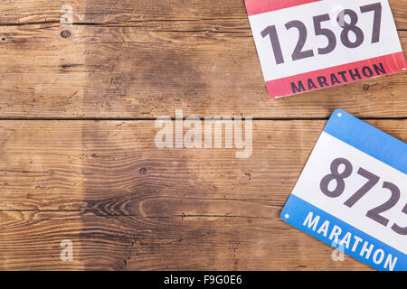 Zwei Marathon-Startnummer gelegt auf einem Holzboden-Hintergrund Stockfoto